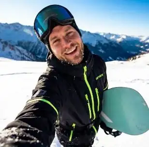 Åkare tar en selfie med en grön snowboard i alpmiljö, framtagen med AI