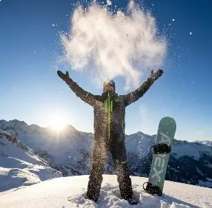 Åkare kastar snö mot solen med utsträckta armar, framtagen med AI